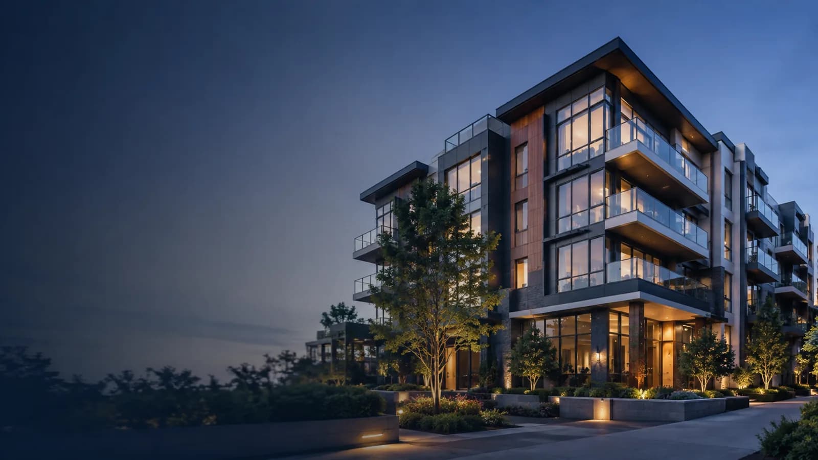 A modern low-rise apartment building lit at dusk